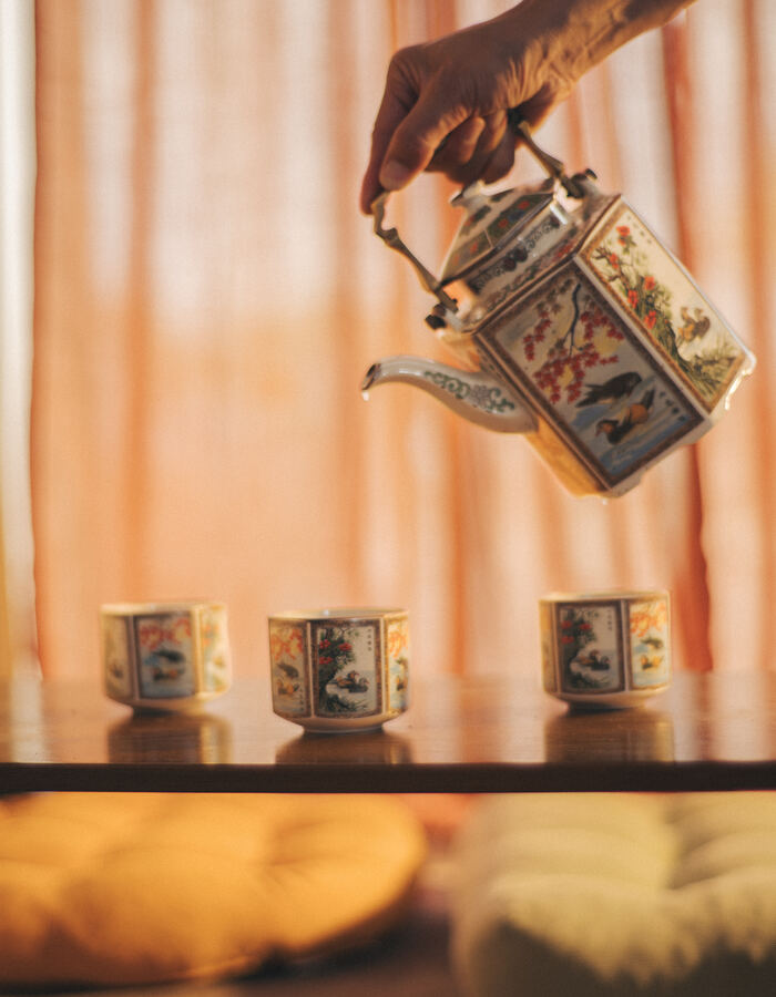 Pouring tea from a hand-painted teapot
